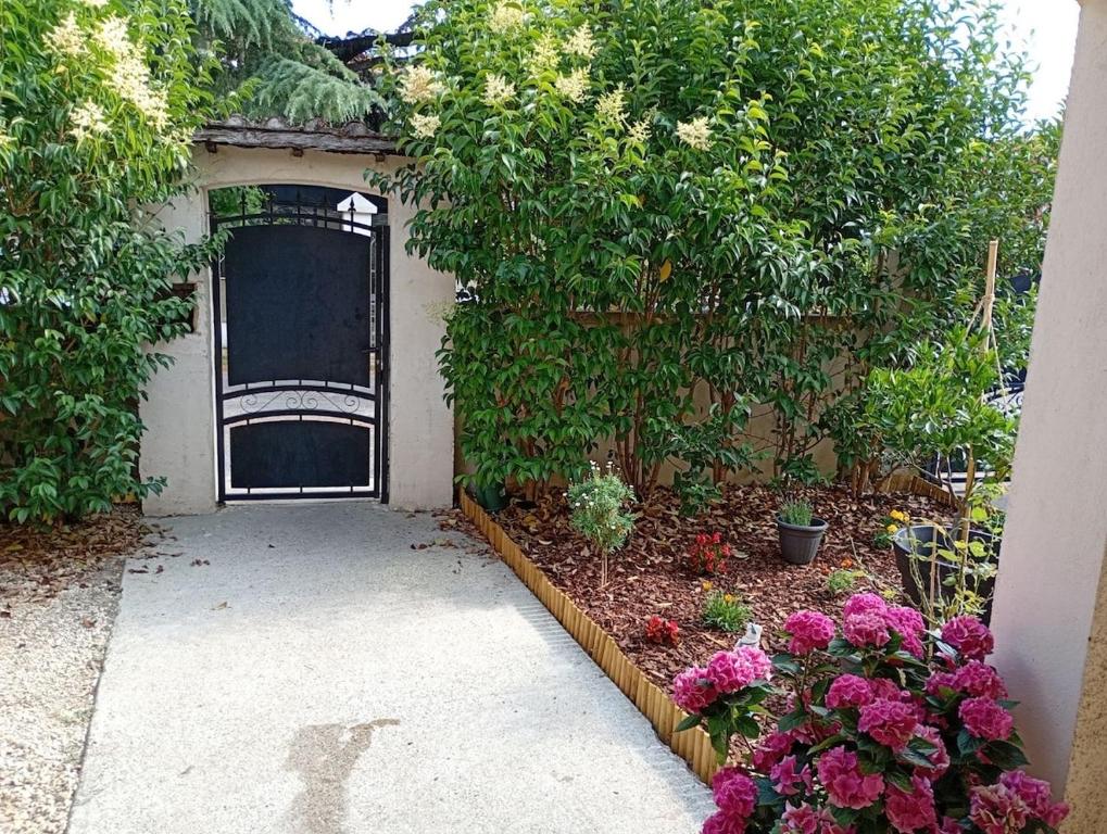 un jardín con una puerta y algunas flores en Maison, en Alès