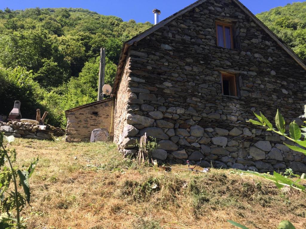 an old stone house on a hill with trees at L'abri de rioumaou in Saligos