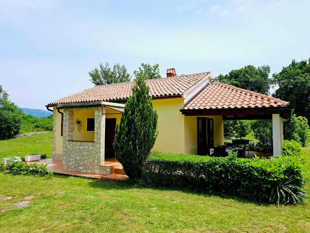 una pequeña casa amarilla con cenador en Casa Ondina - Istrian traditional house, en Šumber