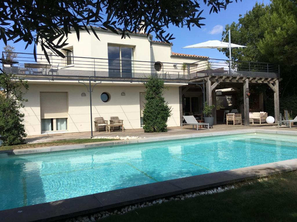 a house with a swimming pool in front of a house at Les Terrasses de Thau in Marseillan