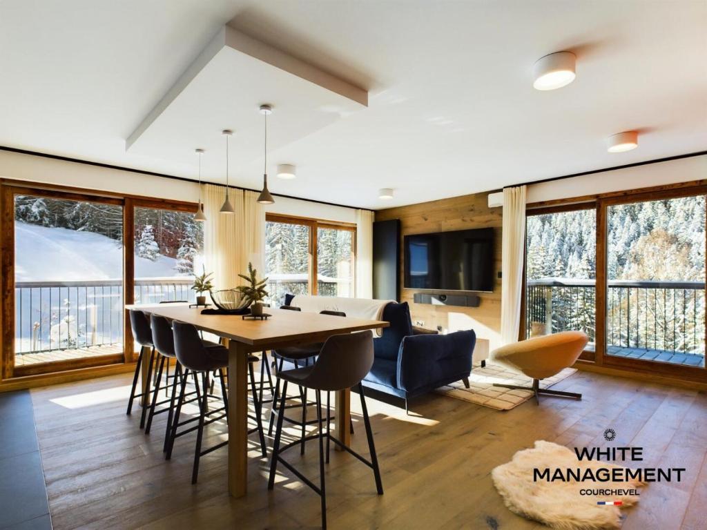 une cuisine et une salle à manger avec une table et des chaises dans l'établissement Résidence Ariondaz Hellebore - Superbe appartement haut de gamme et ski-in MAE-4714, à Courchevel