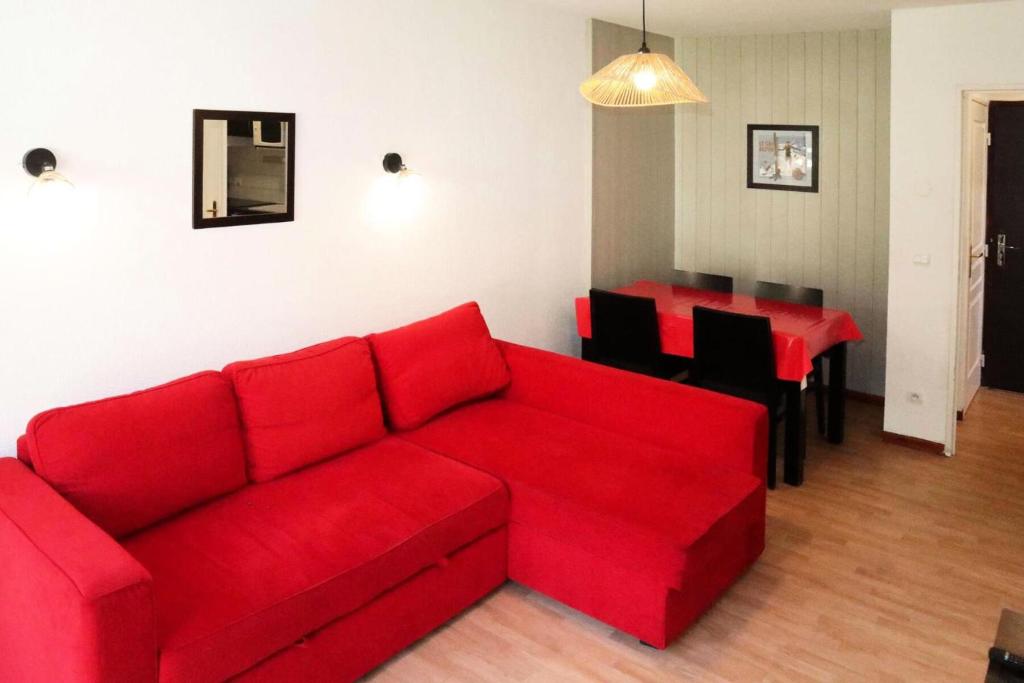 un salon avec un canapé rouge et une table dans l'établissement Residence La Combe D Or - Appartement en résidence de standing MAE-6344, aux Orres