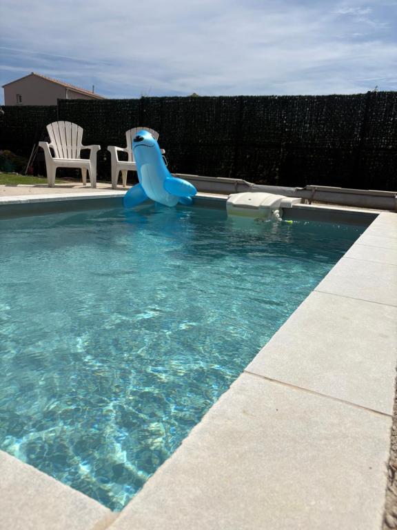 une piscine avec un toboggan bleu dans l'eau dans l'établissement Villa de l olivier en Provence, à Piolenc
