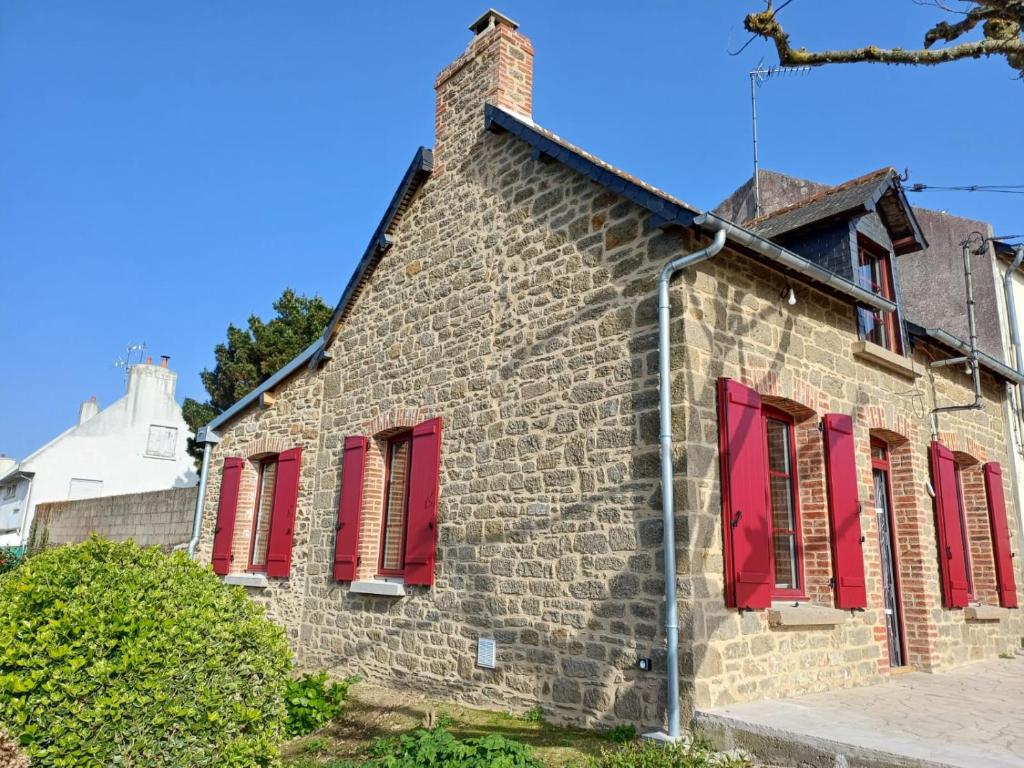 ein altes Backsteingebäude mit roten Fensterläden in der Unterkunft Maison traditionnelle en pierre - Penn'ti in Cancale