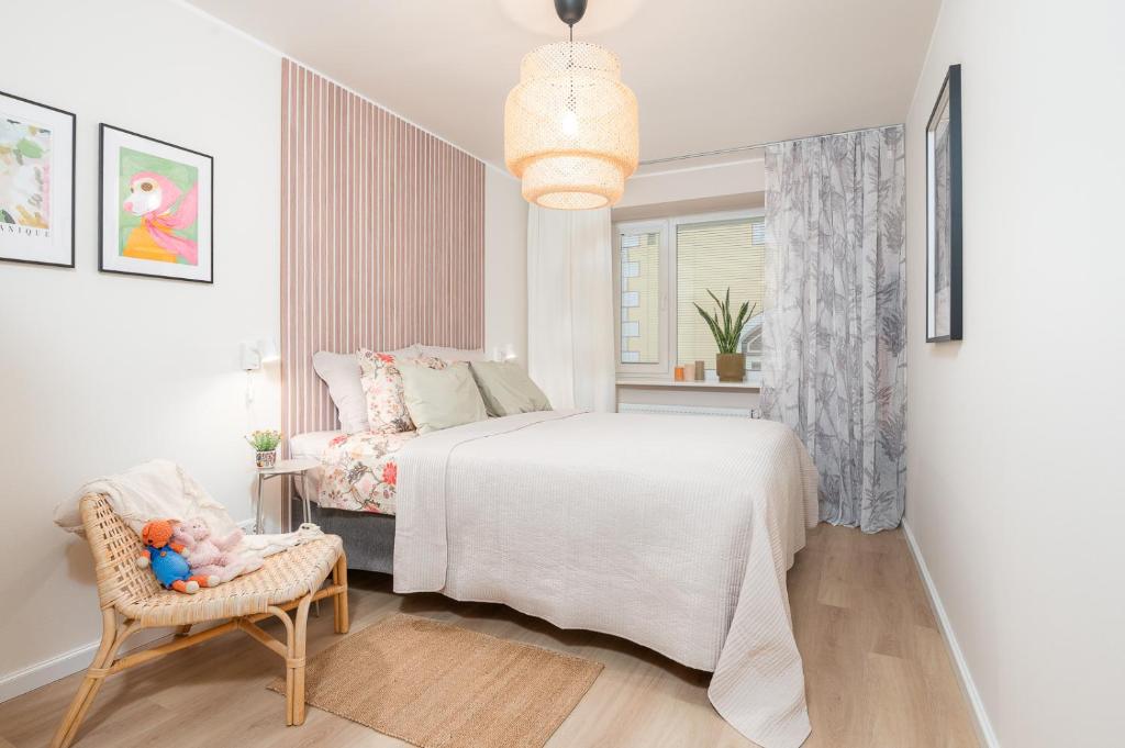 Un dormitorio con una cama y una silla y una ventana. en Apartement Nikolai, en Pärnu
