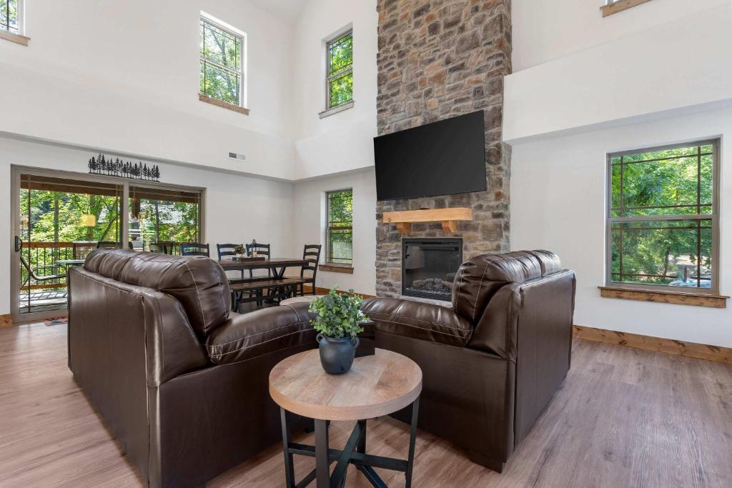 a living room with leather furniture and a fireplace at Peaceful Timbers Getaway in Hollister