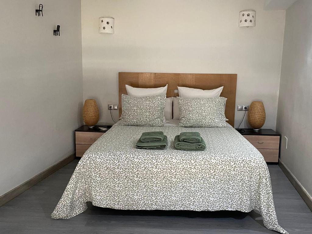 - une chambre avec un lit et 2 serviettes vertes dans l'établissement Apartamento La Machacona TENERIAS, à Cáceres