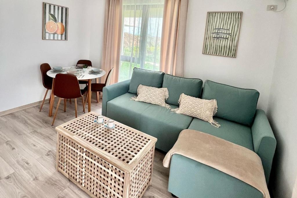 a living room with a green couch and a table at SeaTok & Stay in Costinesti
