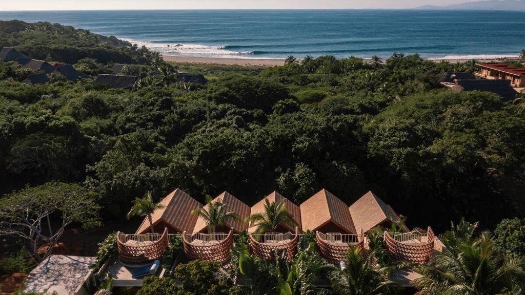 an aerial view of a resort with the ocean in the background at Casa Palmeras 1 - Amazing Beach House in Brisas de Zicatela