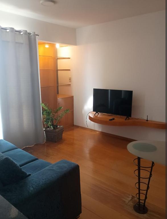 a living room with a couch and a flat screen tv at Kitnet central in Franca