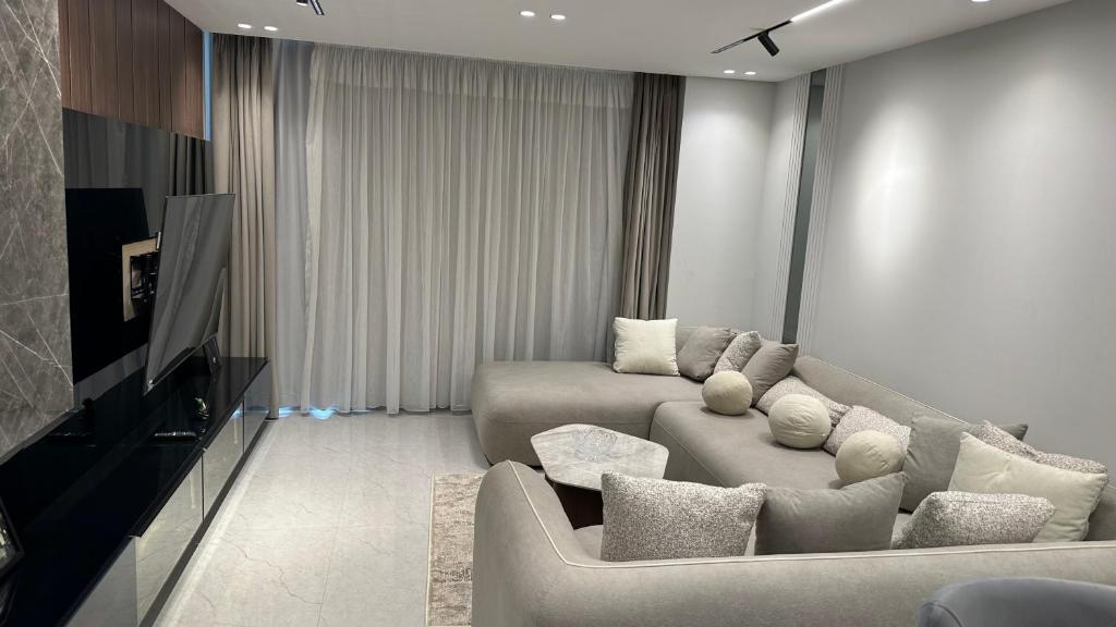 a living room with a couch and a tv at Marwa Galal in Abū Rawwāsh