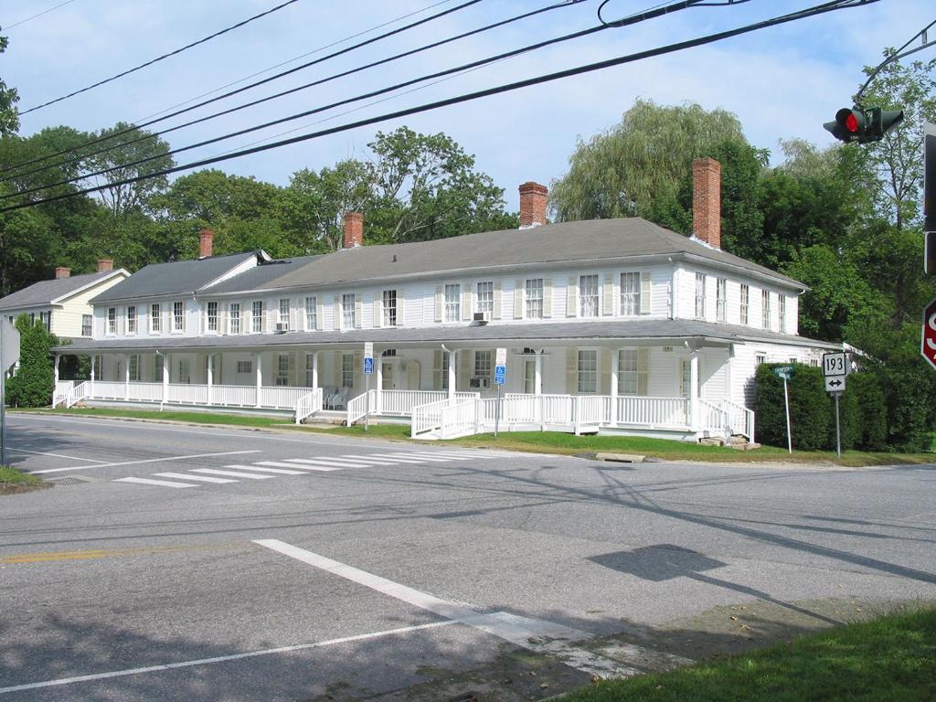 an old white house on the corner of a street at The Cottage House in Thompson