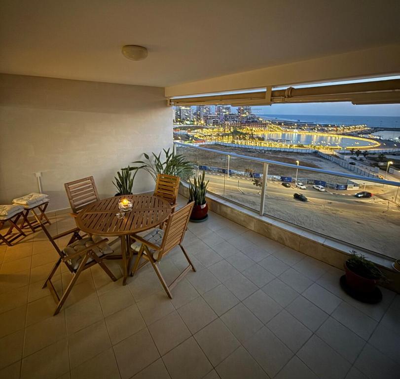 a balcony with a table and chairs and a view of the ocean at Sea Breeze - Modern Marina Stay in Ashdod