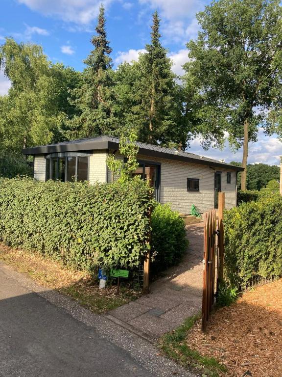 a house with a fence in front of it at Relax Chalet Veluwe in Putten