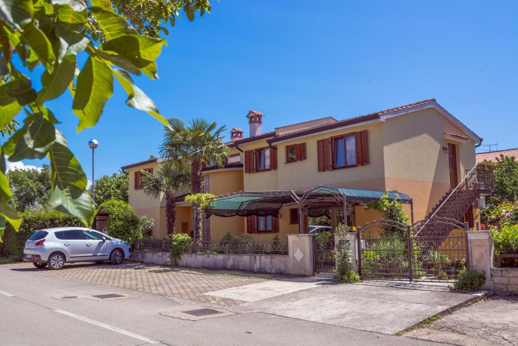 a house with a car parked in front of it at Apartments Masek in Poreč