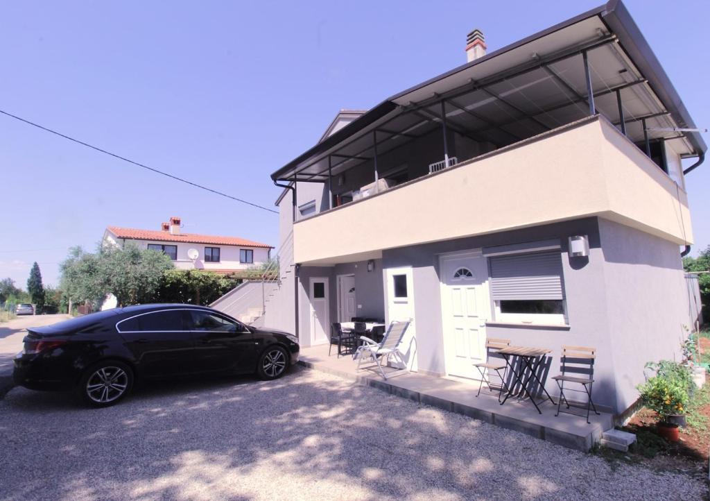 a black car parked in front of a house at Apartments Sidro in Savudrija