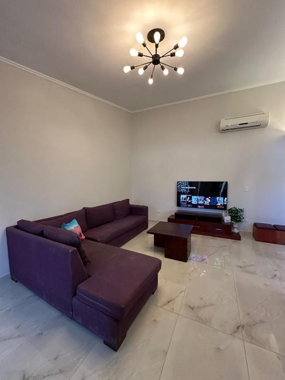 a living room with a couch and a ceiling fan at Beach House - Ramsis Village in ‘Izbat aţ Ţayrīyah