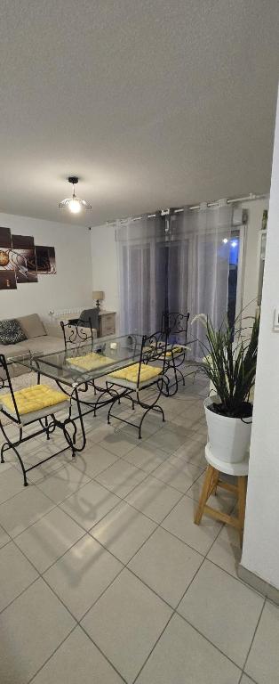 un salon avec une table en verre et des chaises dans l'établissement T2 42 m2 private residence parking, au Cannet