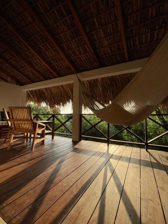 a porch with a hammock and chairs on a deck at Cabañas Uma 2 in San Agustinillo