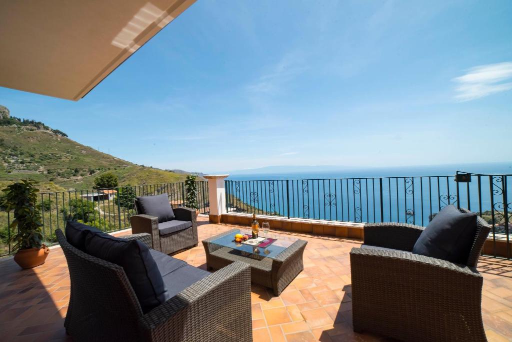 a patio with chairs and a table and the ocean at Villa Sofia in Taormina