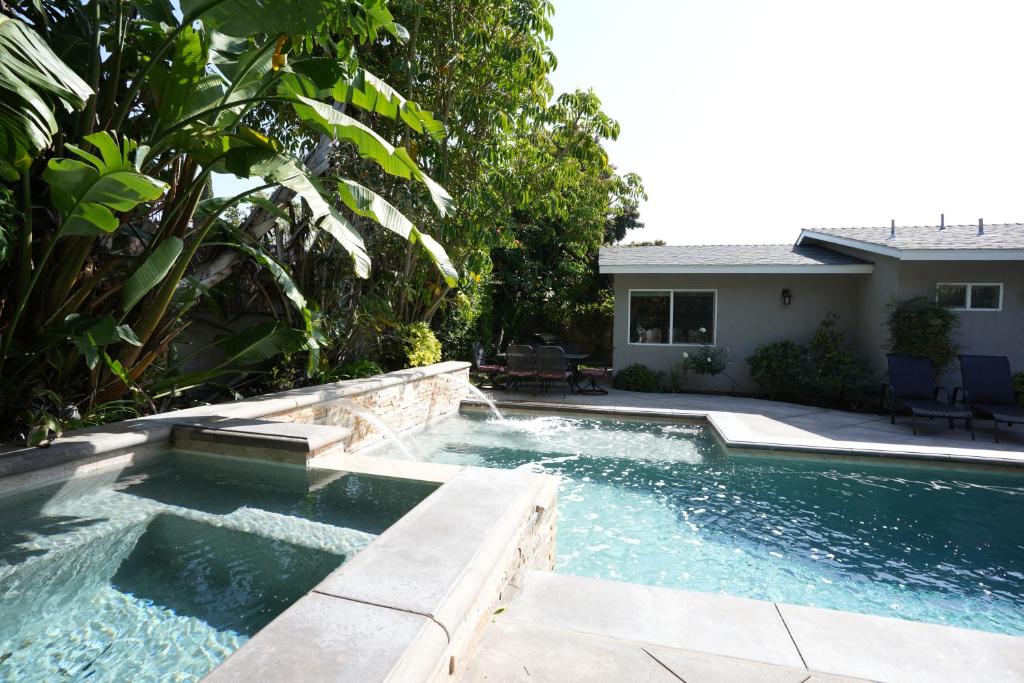 a swimming pool in a backyard with a house at Classy 4 Bedroom 3 Bath Pool Home 3/4 Mile Walk To Disney in Anaheim