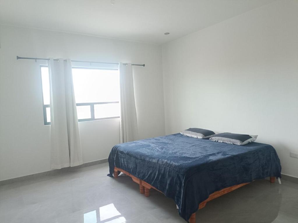 a bed in a white room with a window at Casa San Rafael Moderna y Elegante in Saltillo