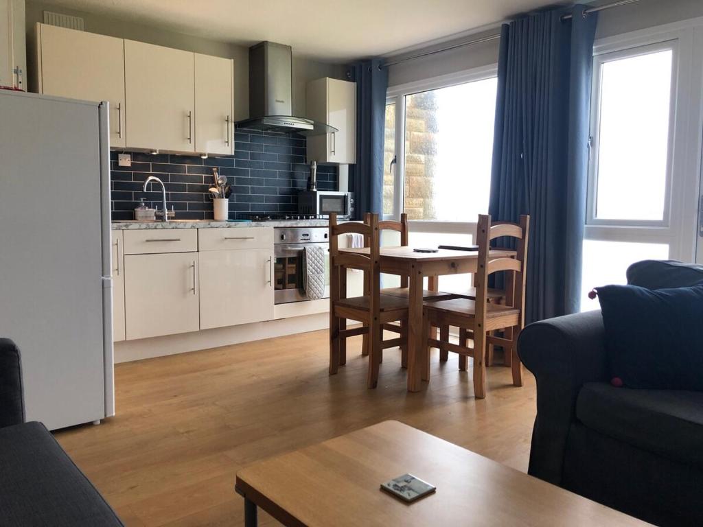 Una sala de estar con una mesa y una cocina. en Fort Albert, en Freshwater