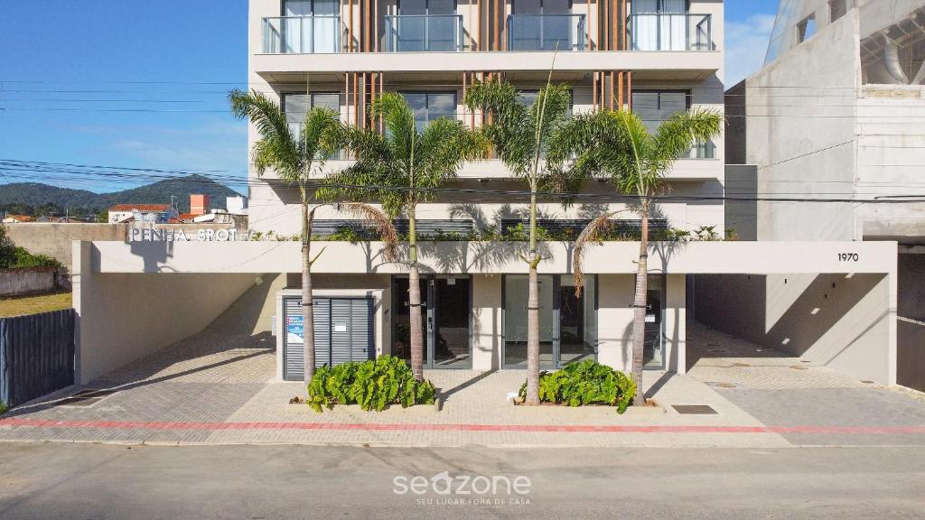 a building with palm trees in front of it at Studios in a seaside building, close to Beto Carreiro at Penha Spot - PSOB in Gravata