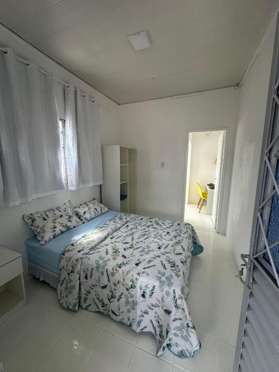 a white bedroom with a bed and a window at Estúdio confortável bem próximo ao Centro de Manaus in Manaus