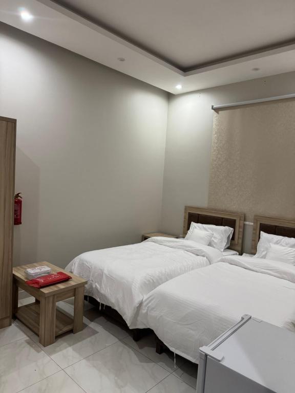 a bedroom with two beds and a table in it at غرفة وحمام مفروشة in Riyadh