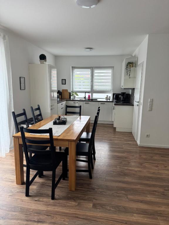 a dining room and kitchen with a wooden table and chairs at Zentral & Ruhig - Apartment für 6 Gäste in Top Lage! in Königswinter