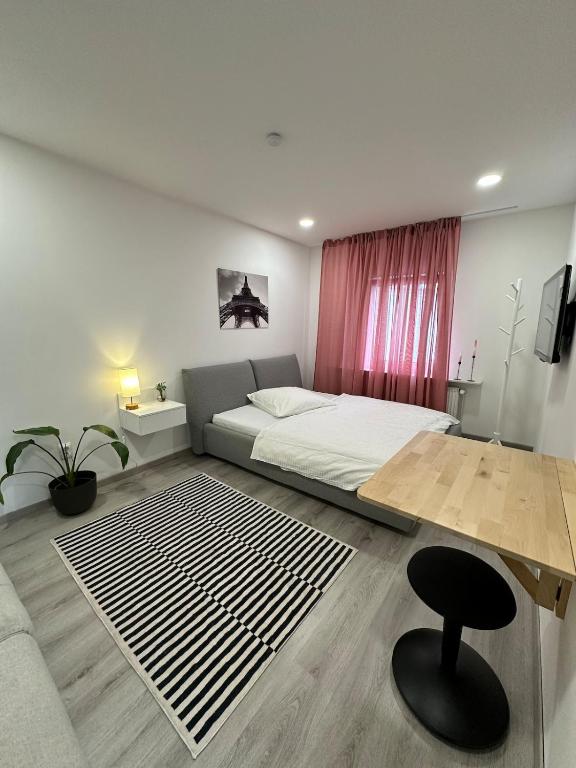 Un dormitorio con una cama, una mesa y una silla. en Charming apartment near the airport, en Langenhagen