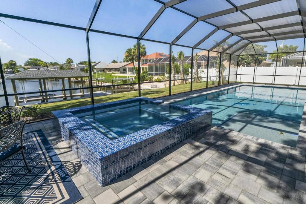 an indoor swimming pool with a large glass roof at Coastal Paradise Waterfront Pool Home in Bon Terra
