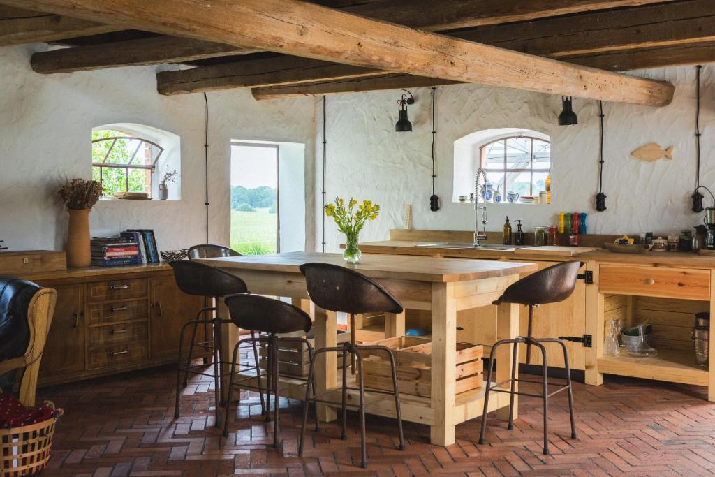 a kitchen with a large wooden table and stools at Sielskie Siedlisko w Czerwonym Dworze in Węgorzewo