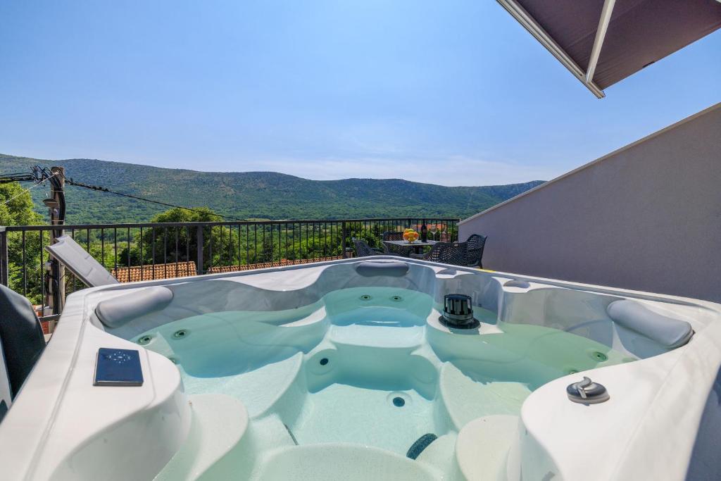 a jacuzzi tub on the balcony of a house at House Maris in Tribalj