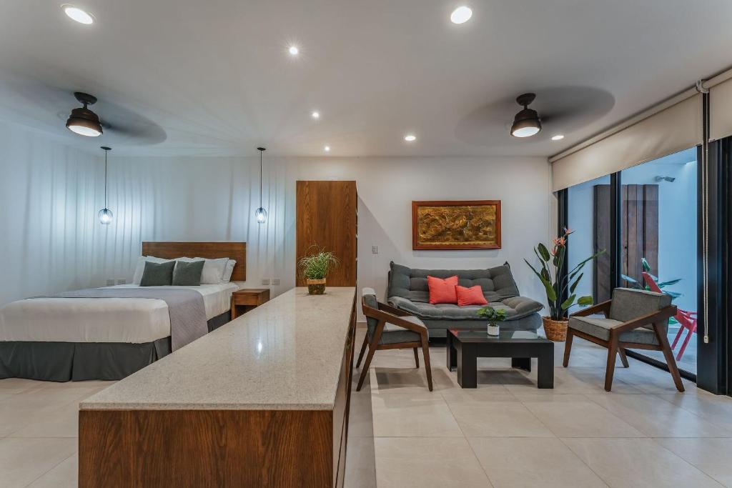 a hotel room with a bed and a living room at Casa Regina Loft Paseo de Montejo in Mérida