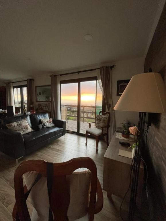 ein Wohnzimmer mit Sofa und Tisch in der Unterkunft Exclusiva casa con hermosa vista in Los Molles