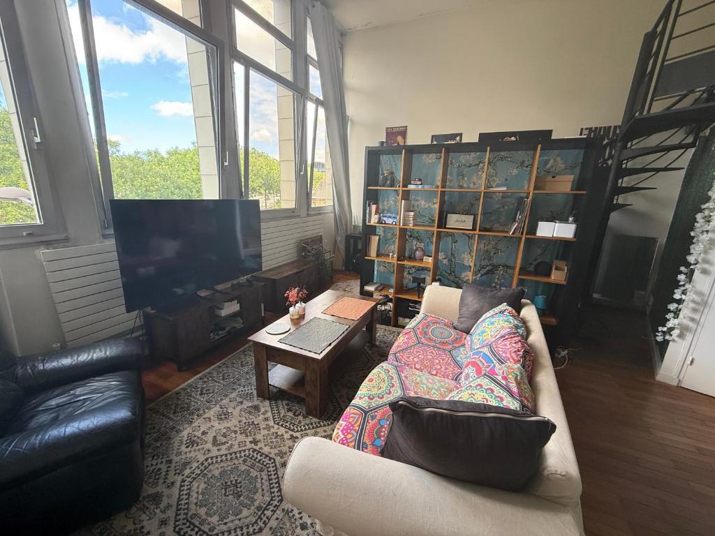 un salon avec un canapé et une télévision dans l'établissement Charmant Duplex aux Portes de Paris, à Ivry-sur-Seine