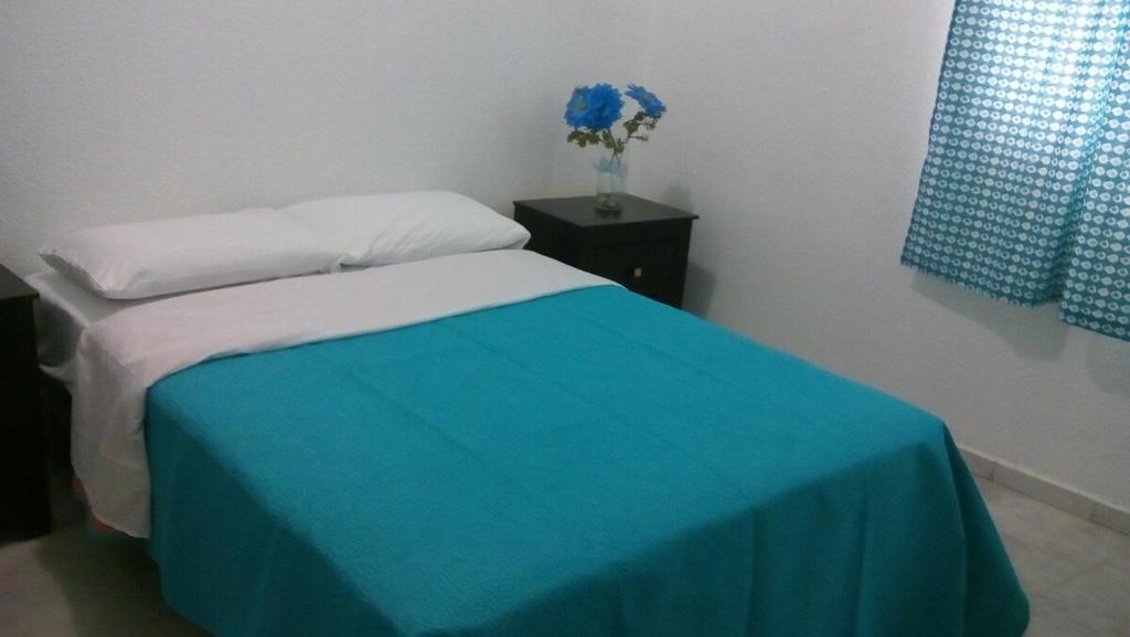 a bedroom with a bed with a blue blanket at Depa 21, Torre Belén, Mazatlán in Mazatlán