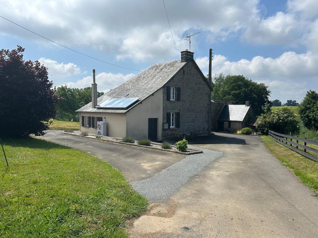 a small house with a roof on a road at Maison de Champeaux in Saint-Fraimbault-sur-Pisse