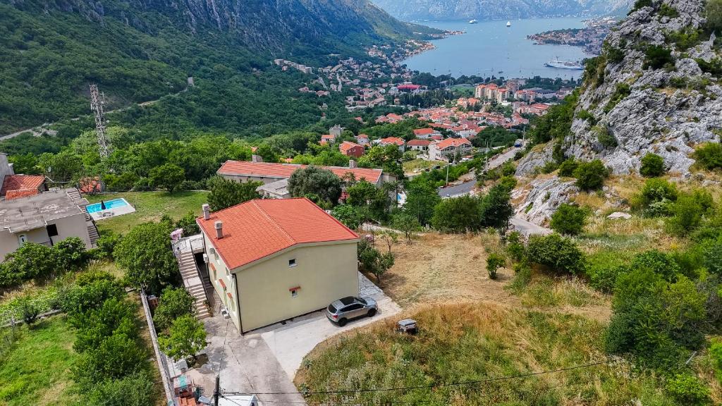 a small house with a red roof on a mountain at Dejana Apartments in Kotor