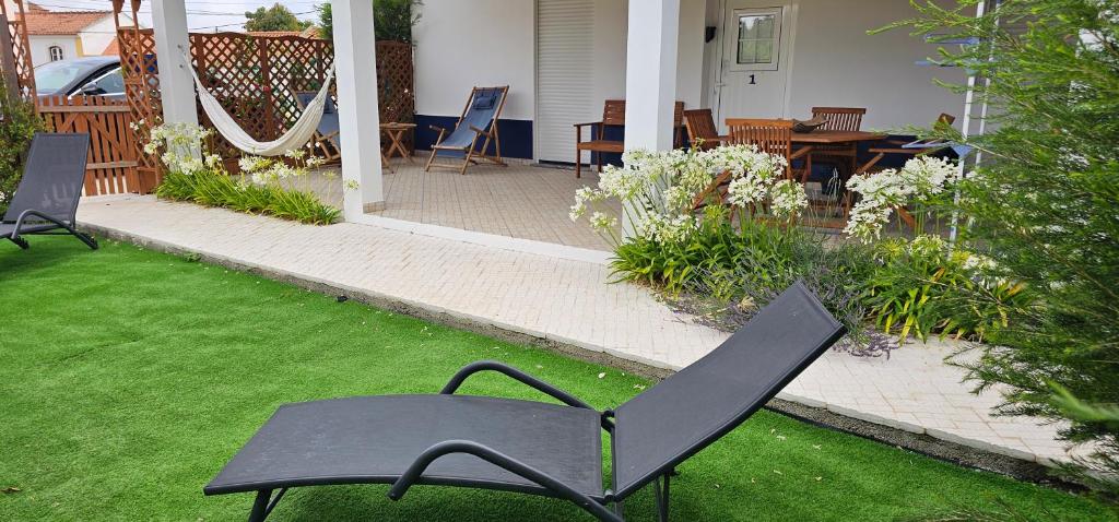 una silla negra sentada en el césped en un patio en Casa do Chafariz - Guest House, en Cercal