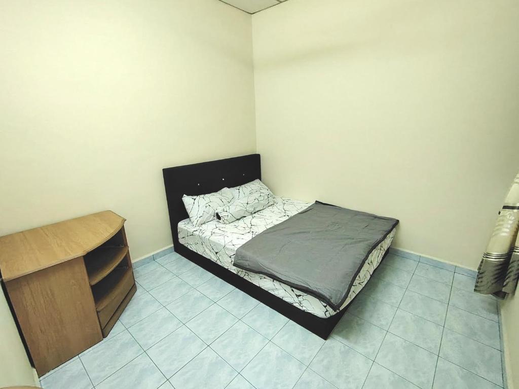 a small bedroom with a bed and a dresser at D'Manjung Samudera Baru HomeSTAY in Seri Manjung