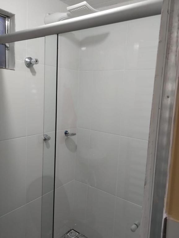 a shower with a glass door in a bathroom at Individual cama in Ouro Preto