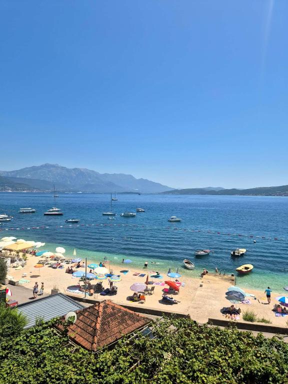 a group of people on a beach with umbrellas at Panorama view apartment VANJA in Baošići