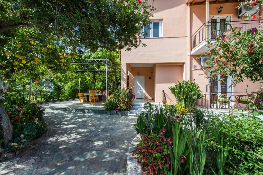 a courtyard of a house with flowers and plants at Zotos Rooms in Parga