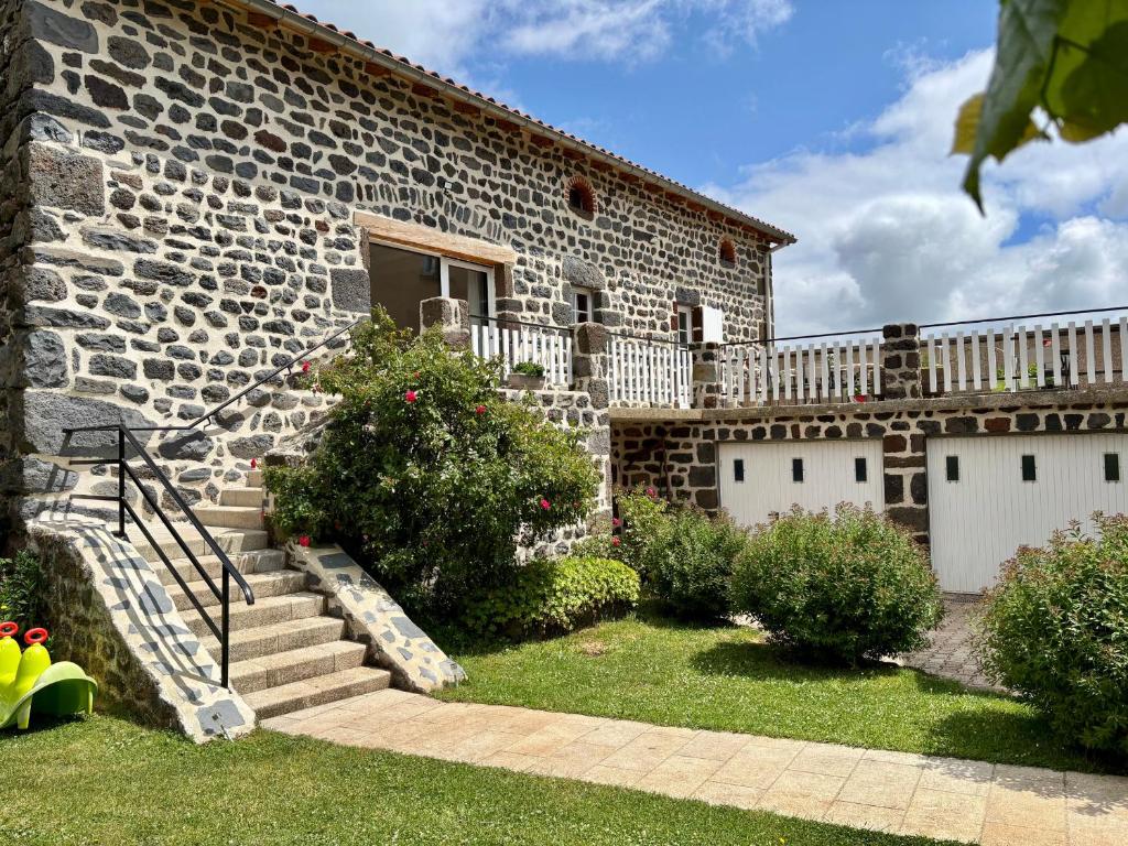 a stone house with stairs and a building at Gîte tout inclus avec terrasse, jardin et parkings, proche Puy-en-Velay et chemins de randonnée. - FR-1-582-323 in Séneujols