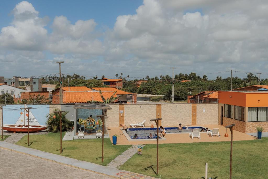 a building with a swimming pool and a playground at Pousada Vila das Lagoas in Santo Amaro