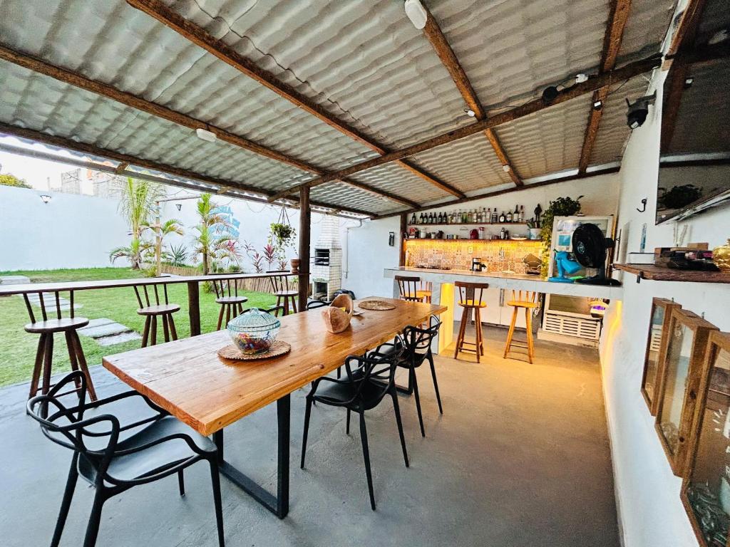 a dining room with a wooden table and chairs at Atenas - Lofts com Cozinha - Próximo Aeroporto e Rodoviária in Porto Seguro