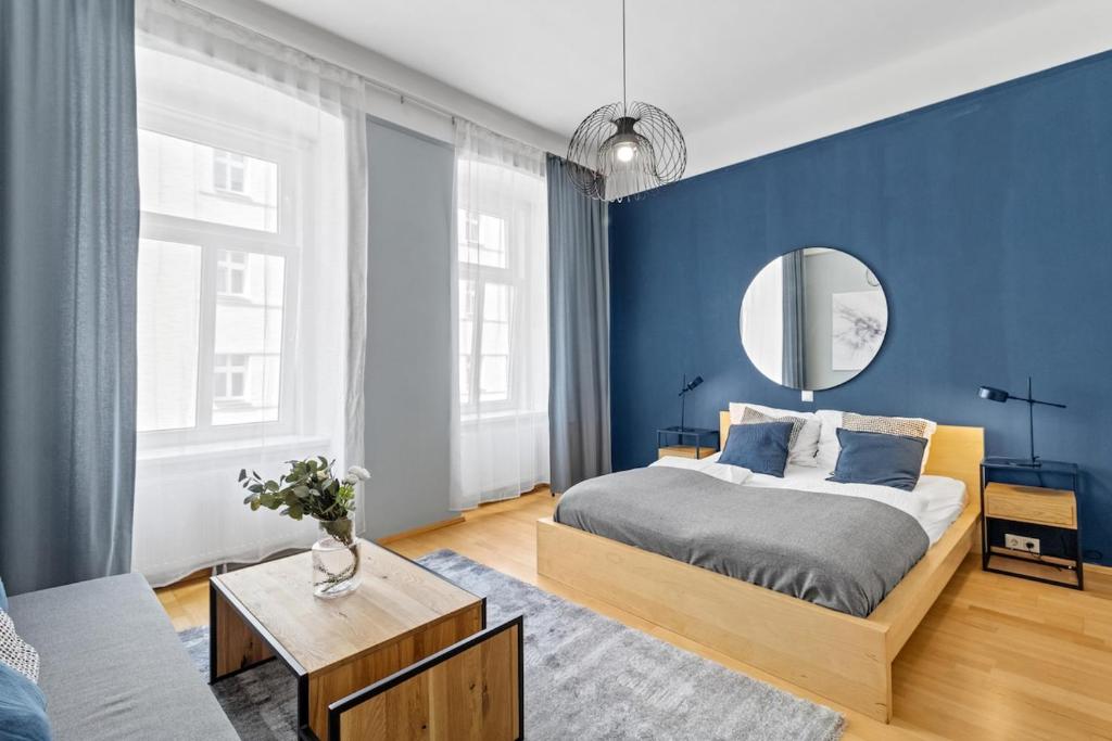- une chambre bleue avec un lit et un miroir dans l'établissement Neben dem Augarten I 5 min to Metro I 10 Min to City, à Vienne